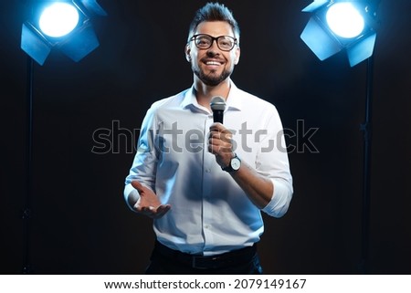 Motivational speaker with microphone performing on stage Royalty-Free Stock Photo #2079149167