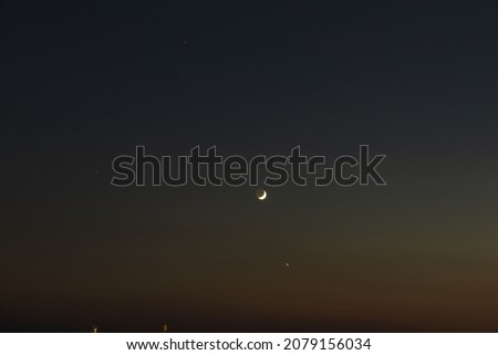Beautiful view of landscape on night sky with a crescent moon and stars.