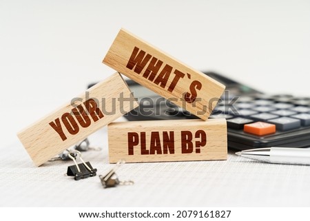 Business and Economics. On the table is a pen, a calculator and small wooden blocks with the inscription - What is Your Plan B