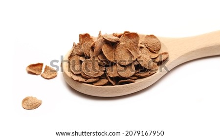 Crunchy corn flakes with cocoa, cereal, muesli pile in wooden spoon isolated on white 