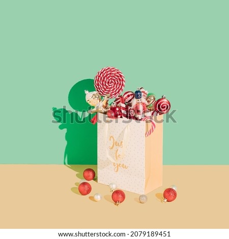 New year sale concept. Christmas decorations fall out from the gift bag on the gold and light green background. 