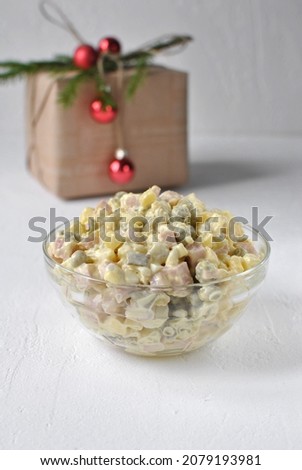 Olivier salad in a transparent plate among the Christmas decor. Traditional Russian New Year's salad.