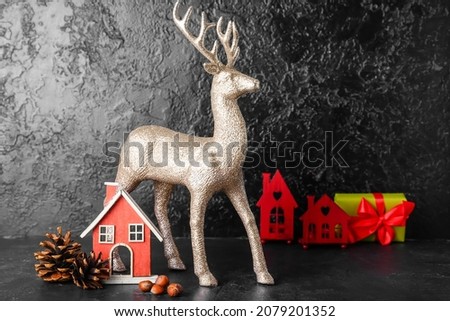 Golden reindeer with Christmas decor on dark background