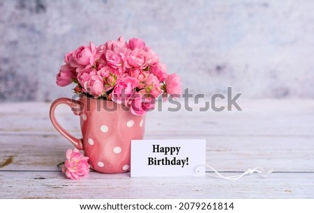 Beautiful Pink Roses in  Vase and Happy Birthday card  on Grey Background  