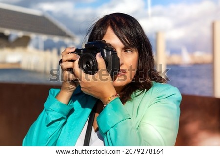 Woman taking a photo with her digital camera, Professional photographer shooting a picture.