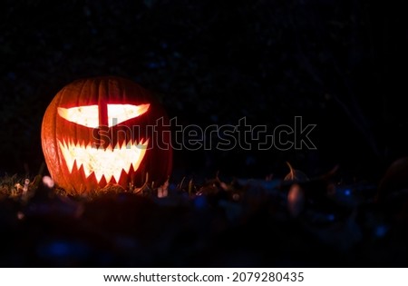 Halloween pumpkins smile and scary eyes for party night on grass