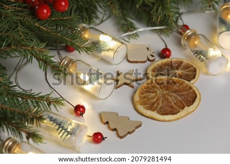 A part of christmas decoration on the white background with different wooden toys and slices of orange