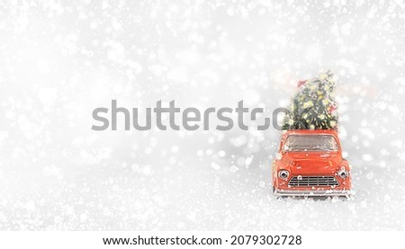 Red Car Carrying Christmas Tree with Lights on a White Snowy Background. Christmas Background