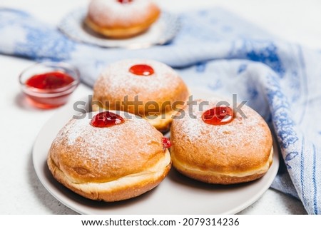 Sufganiyot jelly doughnuts cooked in oil on white table background. Traditional Jewish festive food dessert for Hanukkah holiday. Flat lay, top view