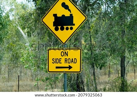 Train crossing ahead on side road roadside sign with bush background