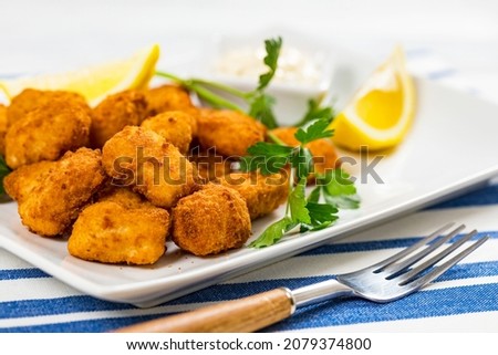Crispy Fish Bites Snack Size. Deep Fried Pollock Fish Fingers with Tartar Dipping Sauce on a Wooden Board. Selective focus. Royalty-Free Stock Photo #2079374800