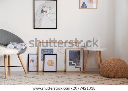 Stylish pictures near light wall