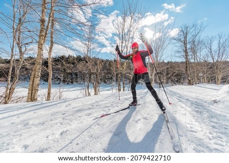 Man Cross Country Skate Skiing Style - Nordic Ski in Forest. Man in winter doing fun endurance winter sport activity in the snow on cross country ski in beautiful nature landscape. Royalty-Free Stock Photo #2079422710
