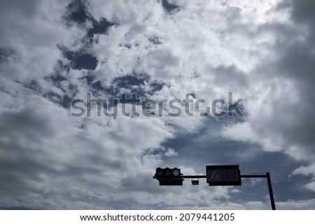 Traffic safety warning on sky, careful transport for pedestrians. Traffic light for urban transport, safety warning sign. Blue sky over the city. Trafic with green trees and traffic lights on blue 