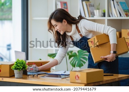 Work from home. happy women selling products online Start a small business owner by using laptop computer to calculate prices and prepare for postage.