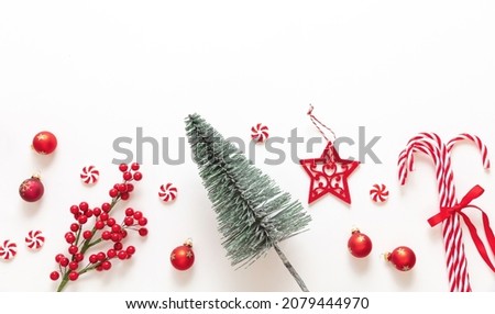 Christmas decoration border isolated on white background. Xmas tree, red baubles, candy canes and ornaments flat lay. New Year greeting card