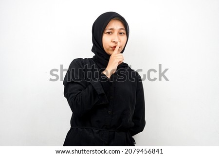 Beautiful asian young muslim woman shh with finger on mouth, telling to be quiet, isolated on white background