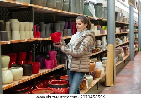 Female seller is standing near clay pots in stock. High quality photo