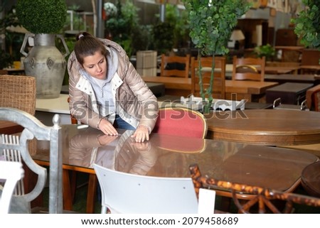 Woman consumer choosing table furniture store. High quality photo