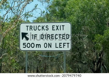 Trucks exit if direction road sign amongst bushland