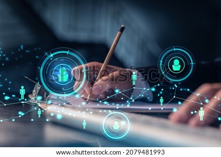 HR specialist is taking notes concerning new candidates to create international network in recruitment process. Concept of success. Social media hologram icons. Formal suit