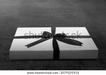 White gift box cap with a black ribbon on the floor. Black Friday concept