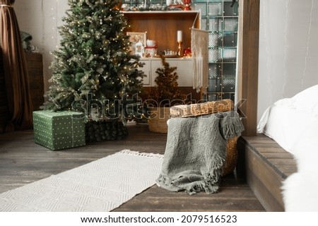 grey Christmas interior natural eco-components. Wicker straw basket for storing clothes on background of scandi style bedroom with wicker baskets and wooden shelves. selective focus