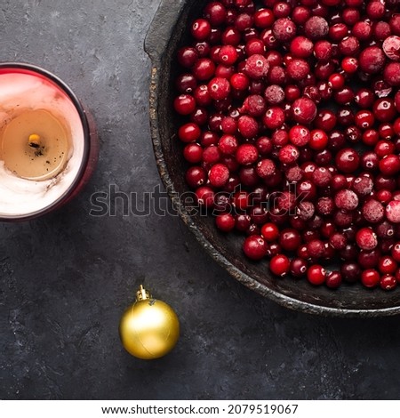 Christmas mulled wine ingredients. Lingonberry, cranberry, red berries, anise, cinnamon, orange on a dark background. Picture of a cozy home holiday. Top view