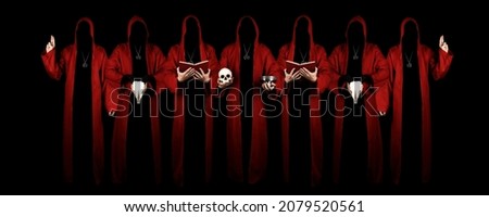 Mystery people in a red hooded cloaks in the dark. Hiding face in shadow. Pointing up with fingers. Satanic symbols. Dark ritual. Sectarians. Isolated on black. Royalty-Free Stock Photo #2079520561