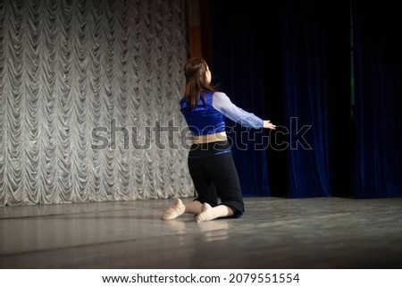 The girl dances on stage. Dance movement. Choreography lesson. The woman performs solo.