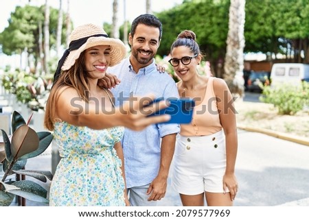 Three hispanic friends smiling happy make selfie by the smartphone at the city.