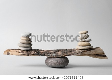 Tree branch with stones on grey background. Harmony and balance concept
