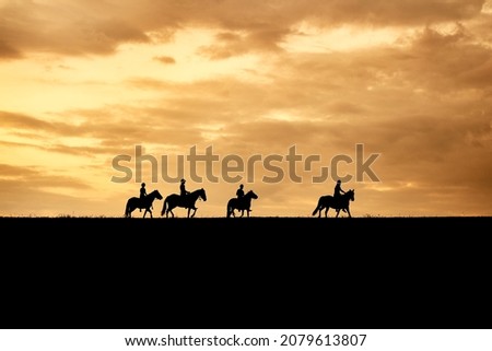 silhouette of horse riders at sunset sky