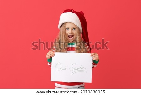 Little girl with letter to Santa on color background