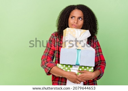 Photo of young pretty african woman embrace present box receive minded look empty space isolated over green color background