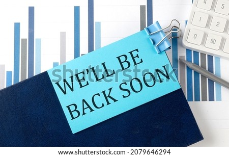 We'll Be Back Soon on sticky note on the notebook on the chart background