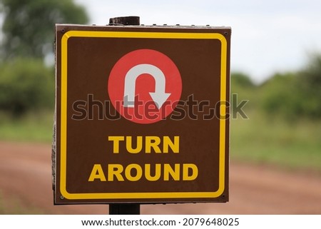 Brown Turn Around Road Sign with blurred background. Direction, mistake, road, travel, choice concept.
