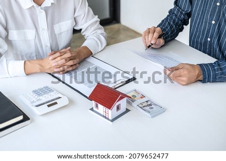 Real estate broker agent consult to customer to decision making sign insurance form and sending house model to client after approve, home model mortgage loan offer for and house insurance.