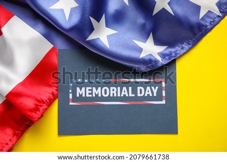 Paper sheet with text MEMORIAL DAY and USA flag on color background