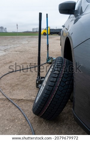 Photo of a wheel near a car for repair and tire fitting