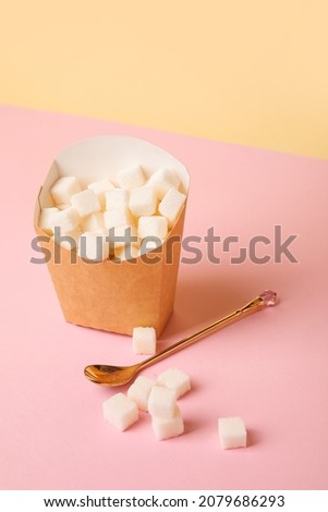 Paper box with sugar on color background. Concept of addiction Royalty-Free Stock Photo #2079686293
