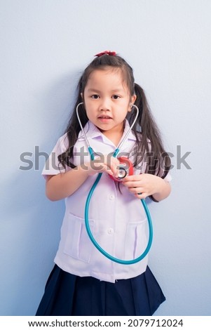 Happy cute girls in white medical uniform and stethoscope act like doctor. child dreams of becoming a doctor career concept.