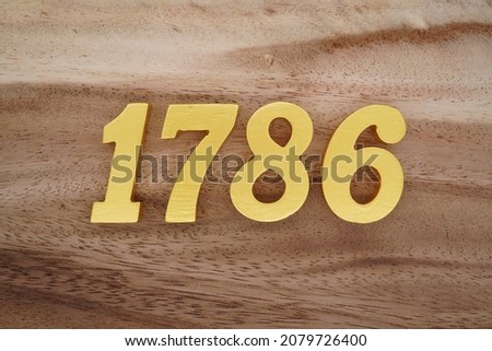 Golden Arabic numerals 1786 on a dark brown to white wood grain background.