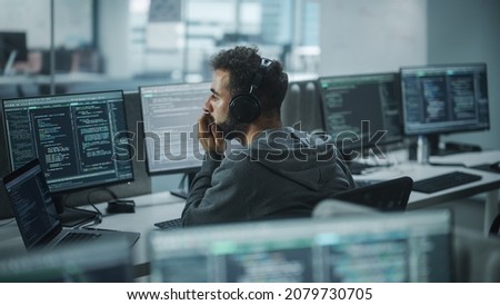 Office: Professional White IT Programmer Uses Headphones while Working on Desktop Computer. Male Website Developer, Software Engineer Developing App, Video Game. Listening to Podcast, Music. Royalty-Free Stock Photo #2079730705