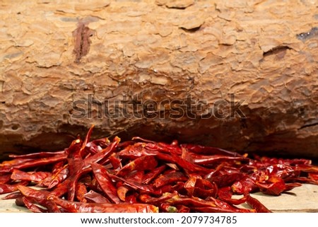 dried hot peppers in front of wood texture
