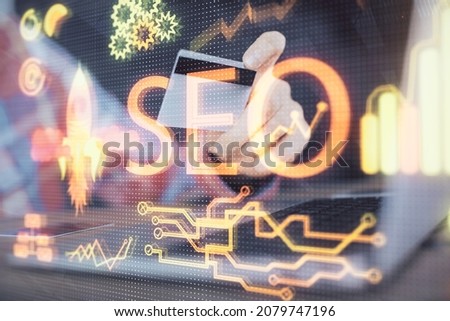 Double exposure of man hands holding a credit card and SEO drawing. Search engine optimization in Internet E-commerce concept.