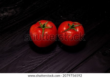 one red tomato on a black background