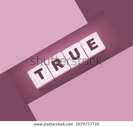 concept word true on wooden cubes on black background