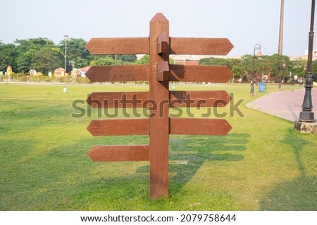 empty wooden signboard on a park , road side , arrow sing, empty arrow signboard