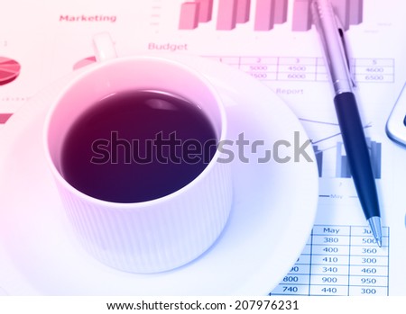 image of workplace with black coffee and financial report on table